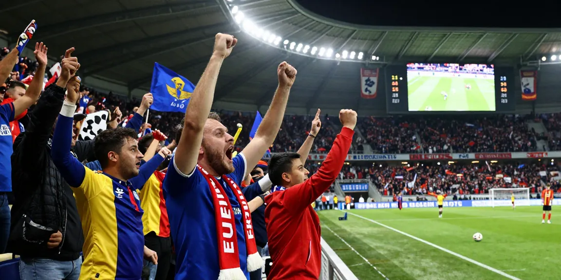 Supporters des matchs de Jupiler Pro League célébrant l'excitation d'un match avec passion et énergie.